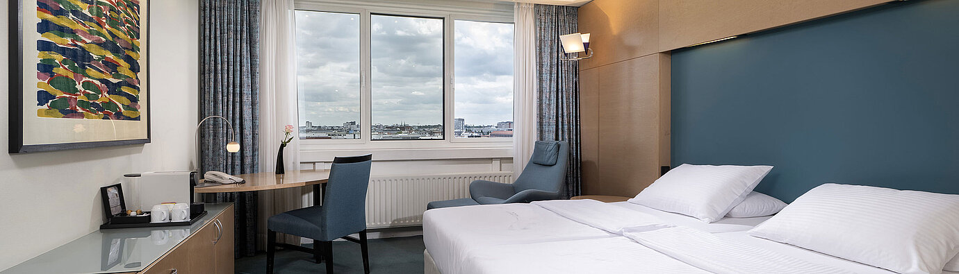 Superior room with double bed, desk, armchair and wide Berlin view at Maritim proArte Hotel