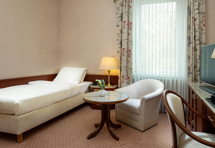 Classic single room Classic single room with bed, seating area, desk and large window in bright traditional design at Maritim Hotel Bad Wildungen.