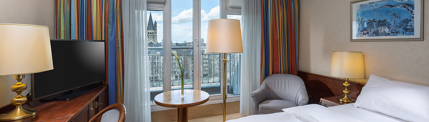 Chambre Classic Chambre Classic à l'Hôtel Maritim Cologne avec lit double, bureau et vue sur le Rhin et le centre historique.