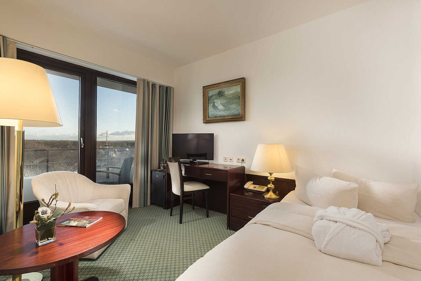 Chambre individuelle lumineuse au Maritim Timmendorfer Strand avec balcon, bureau, coin salon confortable et vue sur la mer.