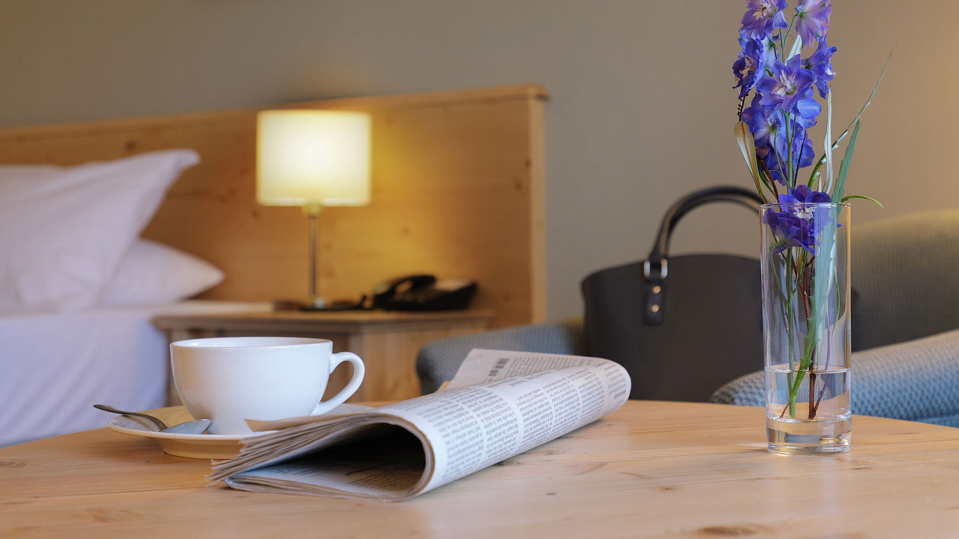 Cup of coffee, newspaper and flower on table in Maritim Hotel Titisee room