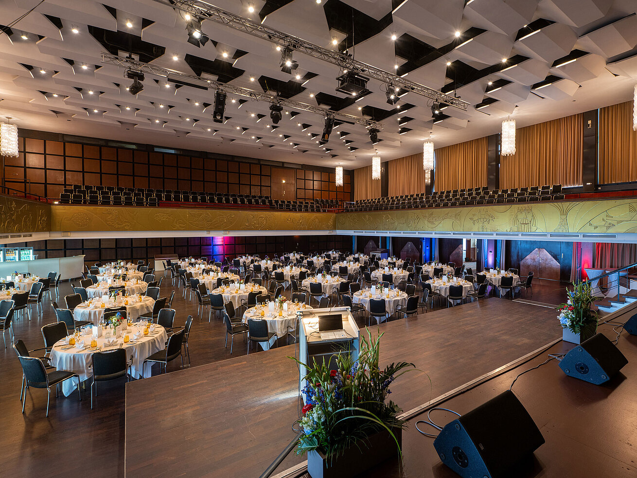 "Saal Maritim" con mesas preparadas, escenario y asientos para un evento