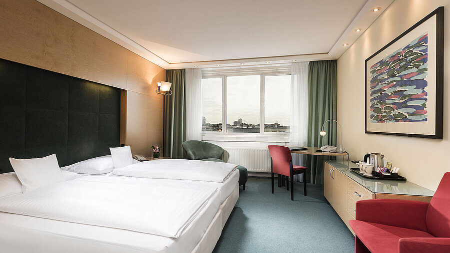 Comfort room at Maritim proArte Hotel Berlin with double bed, desk, chair, and city view.