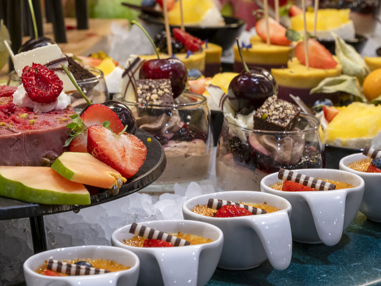 Delicious dessert buffet with crème brûlée, fresh fruits, and chocolate treats at Maritim proArte Hotel Berlin.