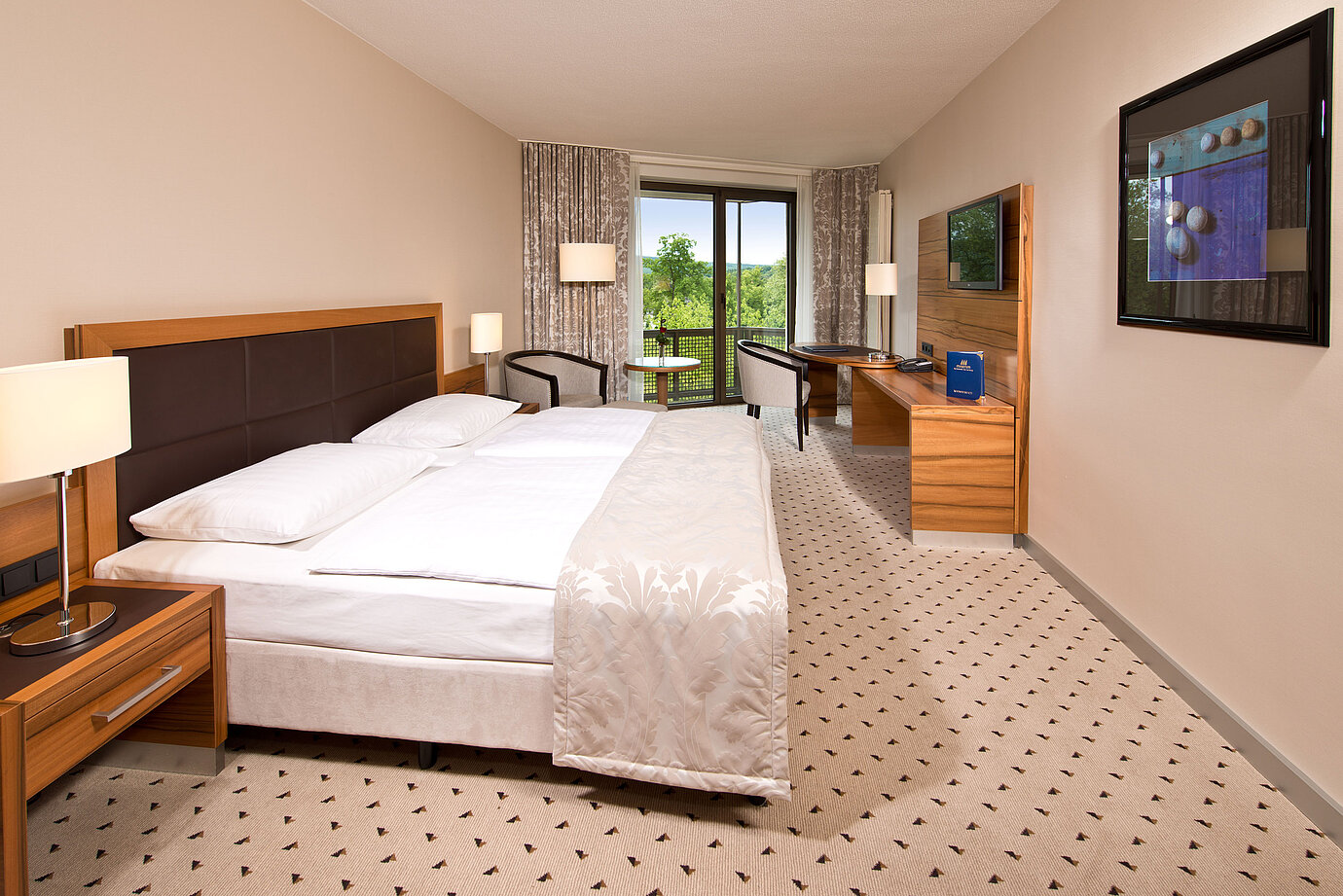 Habitación luminosa en el Hotel Maritim Bad Homburg con cama acogedora, escritorio y balcón con vistas verdes.