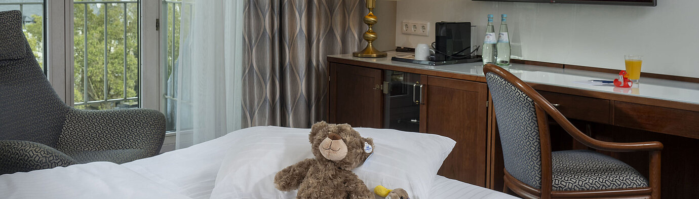 Suite familiale Chambre familiale à l'Hôtel Maritim Cologne avec TV, peluches sur le lit et vue sur le Rhin.