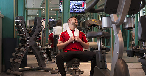 Guest working out in the gym at Maritim Hotel Stuttgart with dumbbells and machines