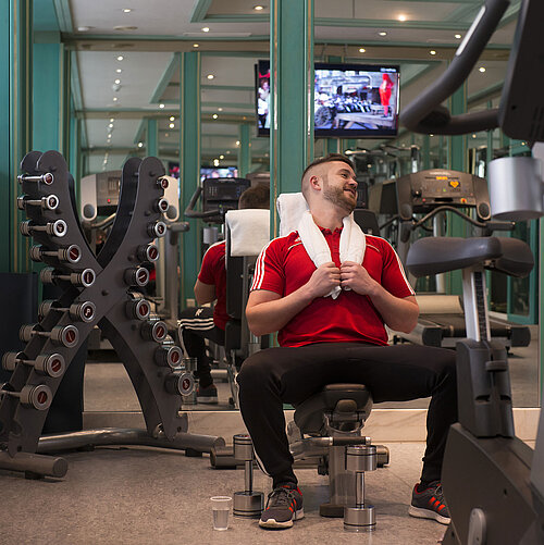 Client s’entraînant dans la salle de sport du Maritim Hotel Stuttgart avec haltères et appareils