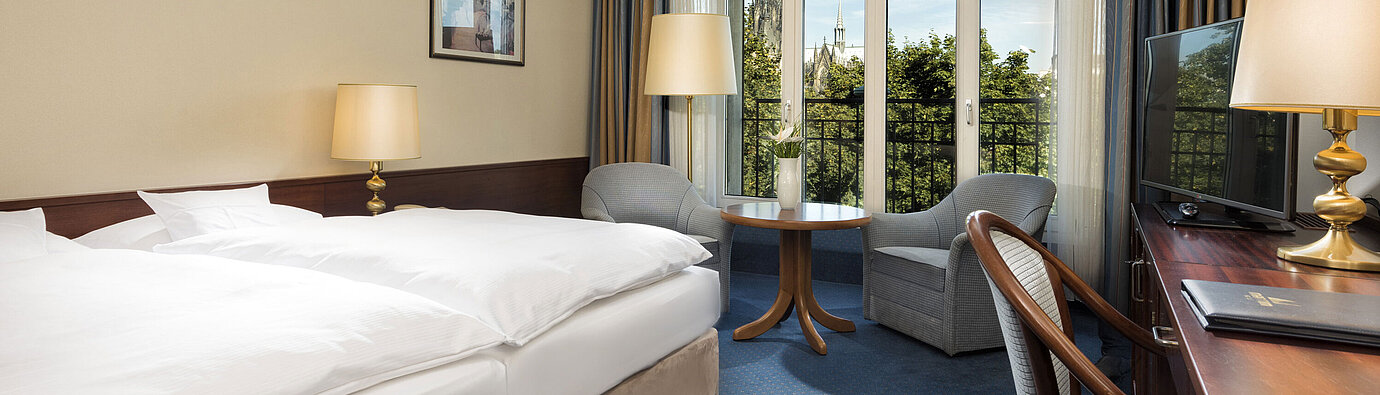 Chambre double supérieure à l'hôtel Maritim Cologne avec décor confortable et vue sur la cathédrale de Cologne.