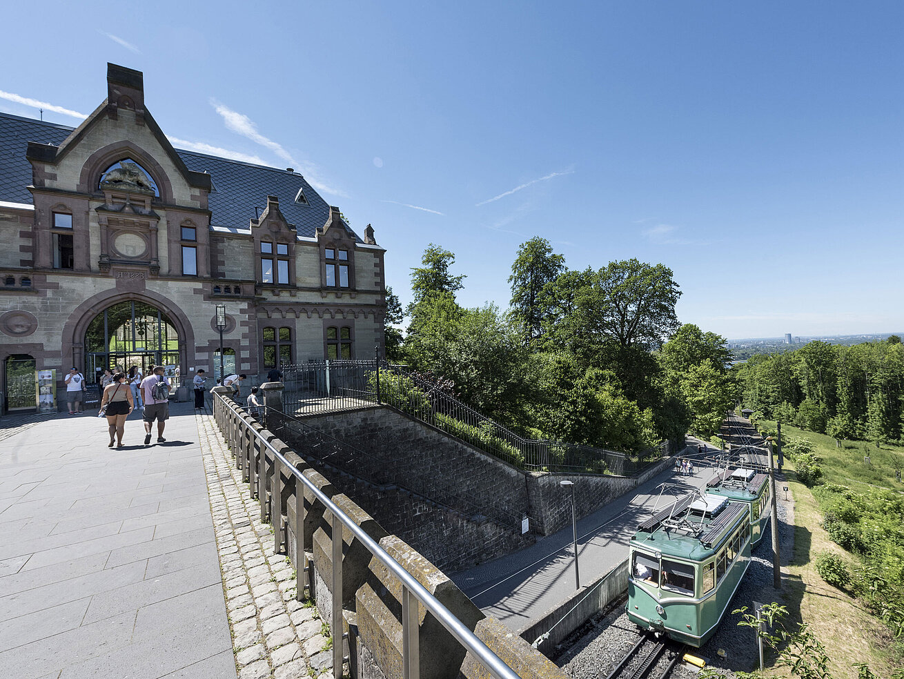The Drachenfelsbahn at the historic station with visitors preparing for the ascent.