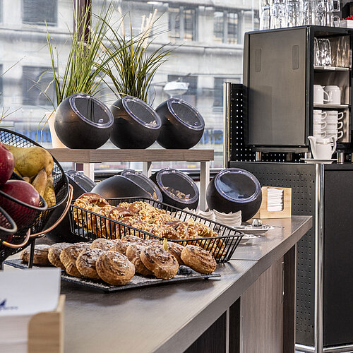 Diverse coffee and snack selection at the Maritim Hotel Magdeburg with fresh pastries, fruit, and modern coffee machines.