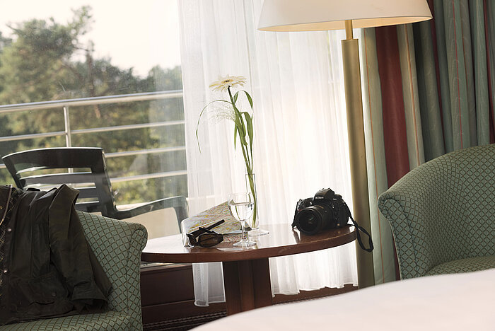 Table avec appareil, plan et verre dans une chambre à l’hôtel Maritim Bad Salzuflen