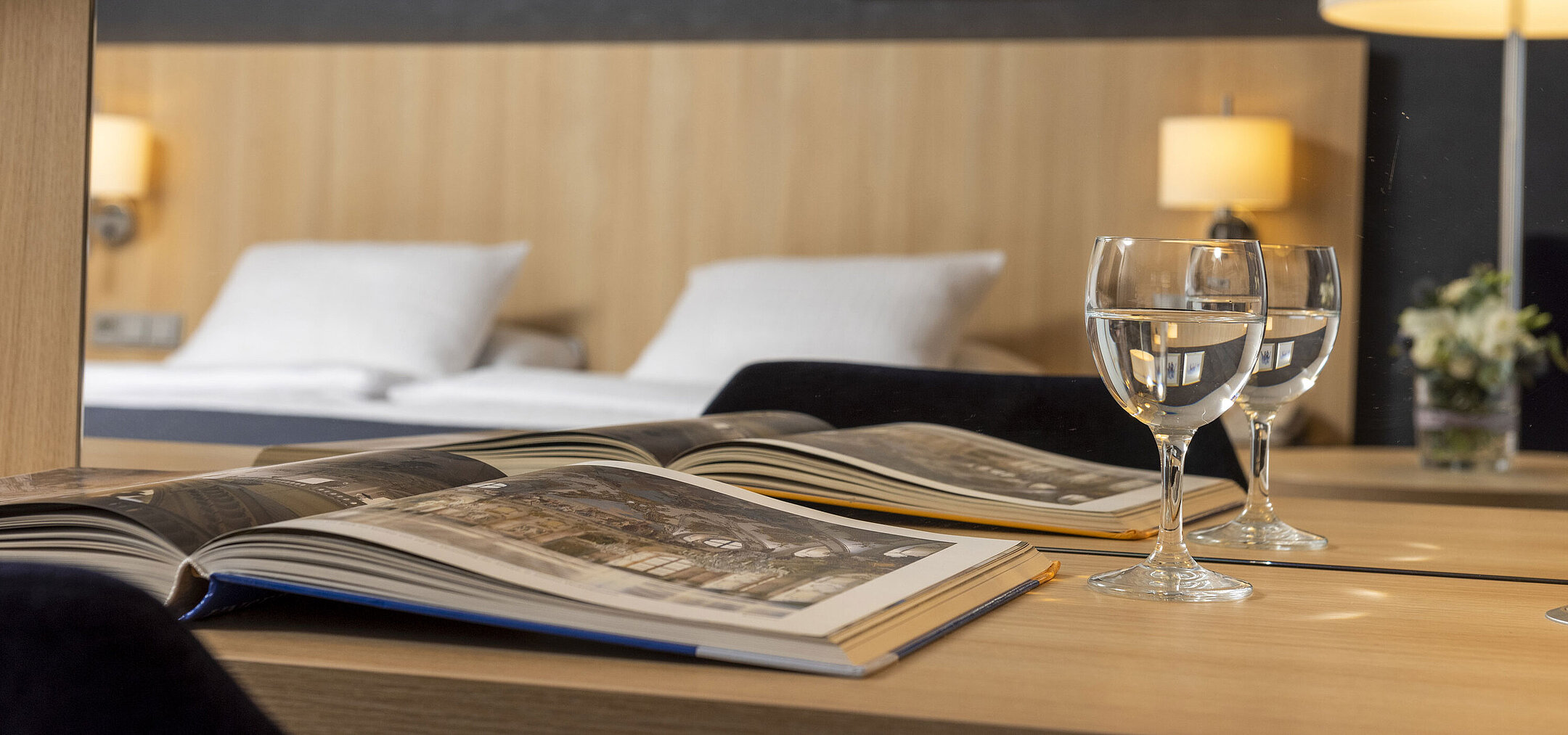 Cozy comfort room at Maritim Hotel Würzburg with mirror, open coffee-table book and water glasses