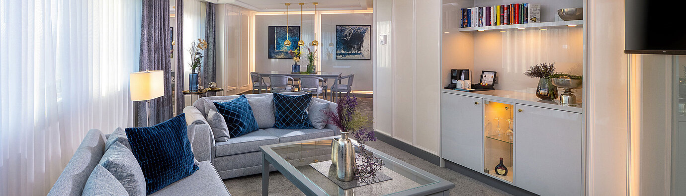 Presidential suite with spacious living area, seating, bar, modern amenities and an elegant atmosphere.