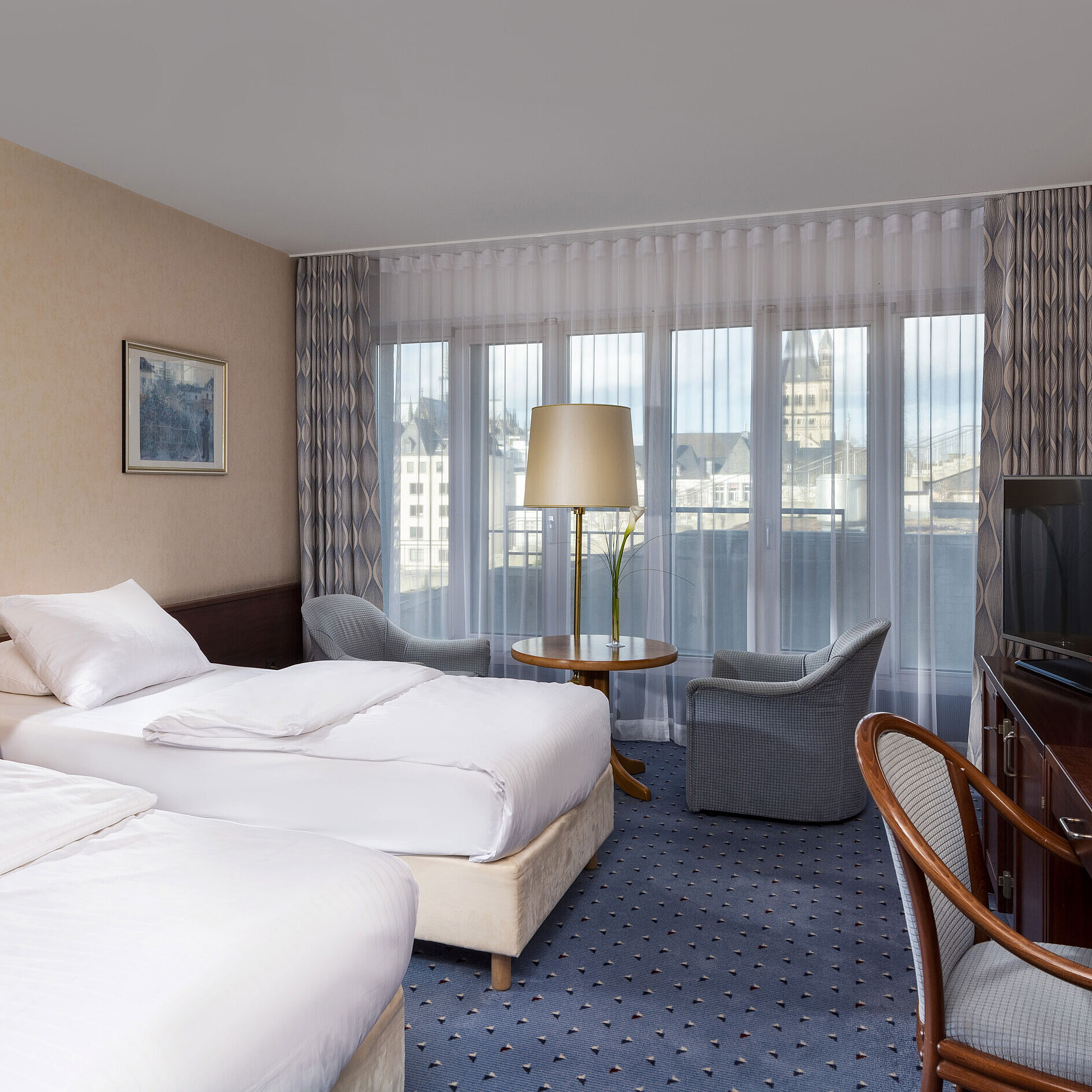 Standard Camera Standard Twin al Maritim Hotel Colonia con due letti, area salotto, scrivania, TV a schermo piatto e ampie finestre.