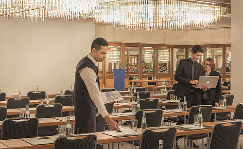 Employé préparant la salle de réunion avec lustres à l’hôtel Maritim Munich
