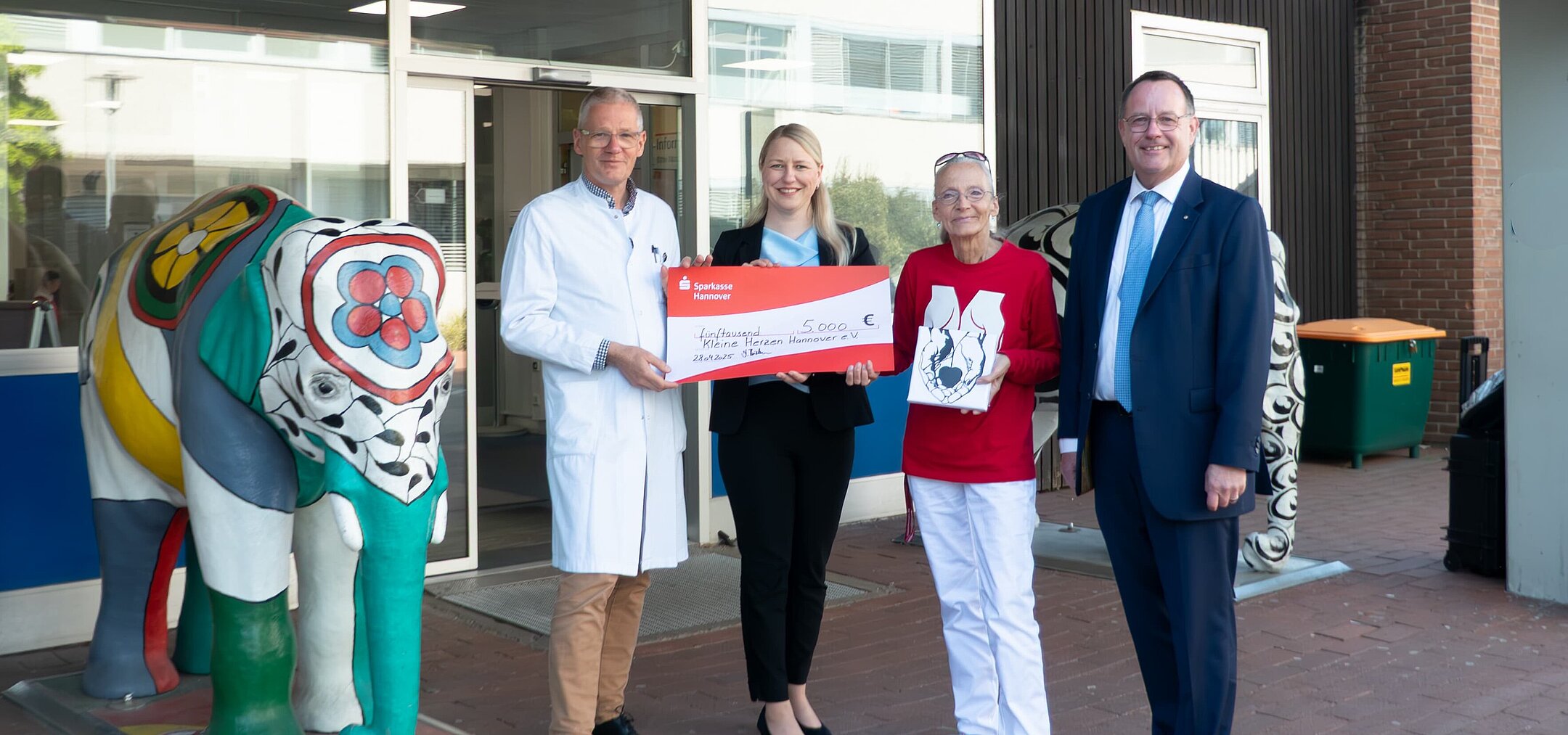 ProTomorrow "Kleine Herzen Hannover" Entrega de un cheque a «Kleine Herzen Hannover» delante del Hospital Infantil de Hannover