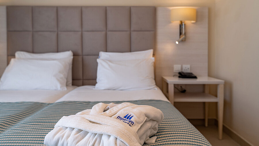 Deluxe Double room Close-up of a hotel bed with bathrobe and soft bedding
