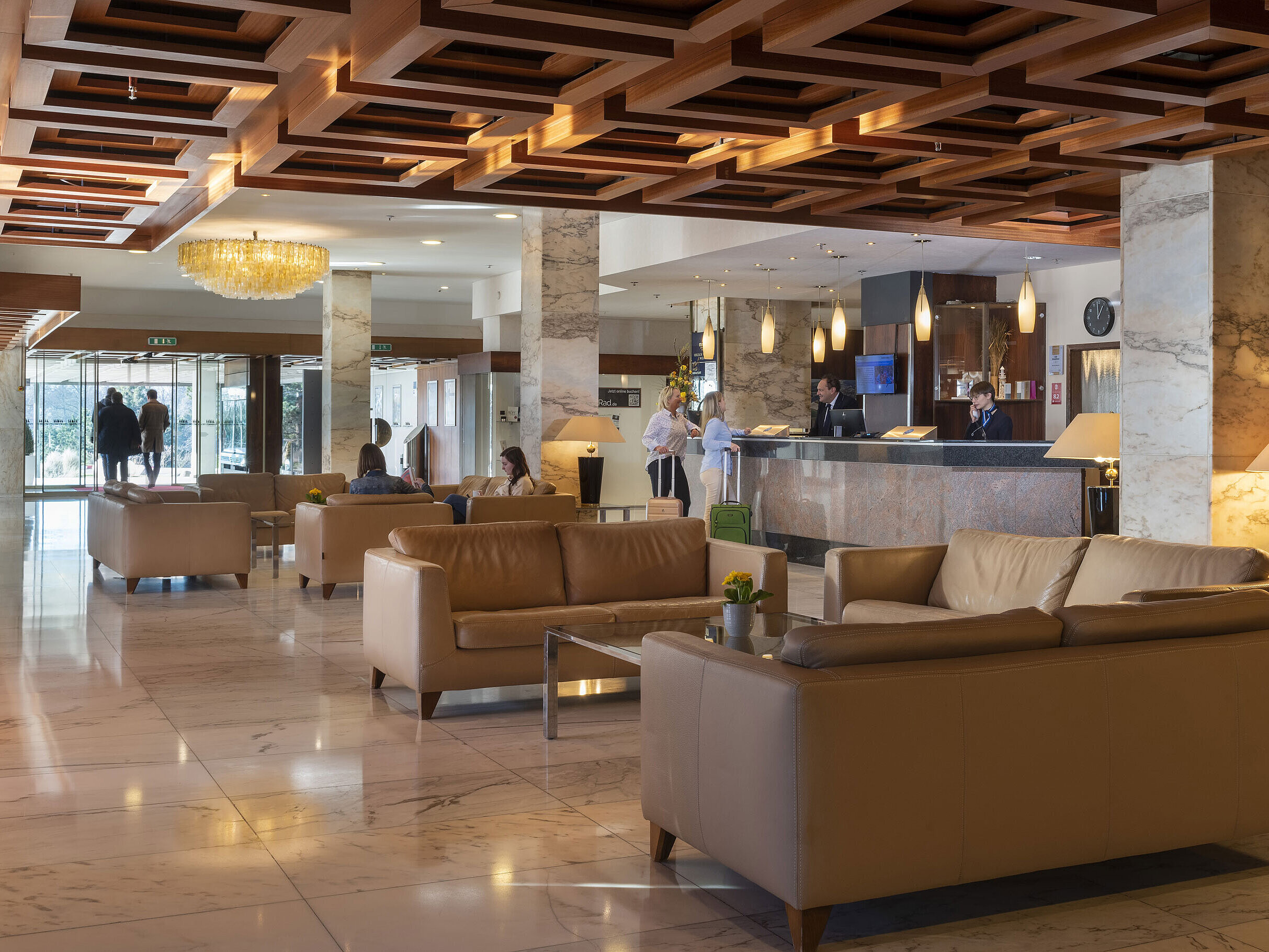 Ampia hall con pavimento in marmo, divani in pelle e reception