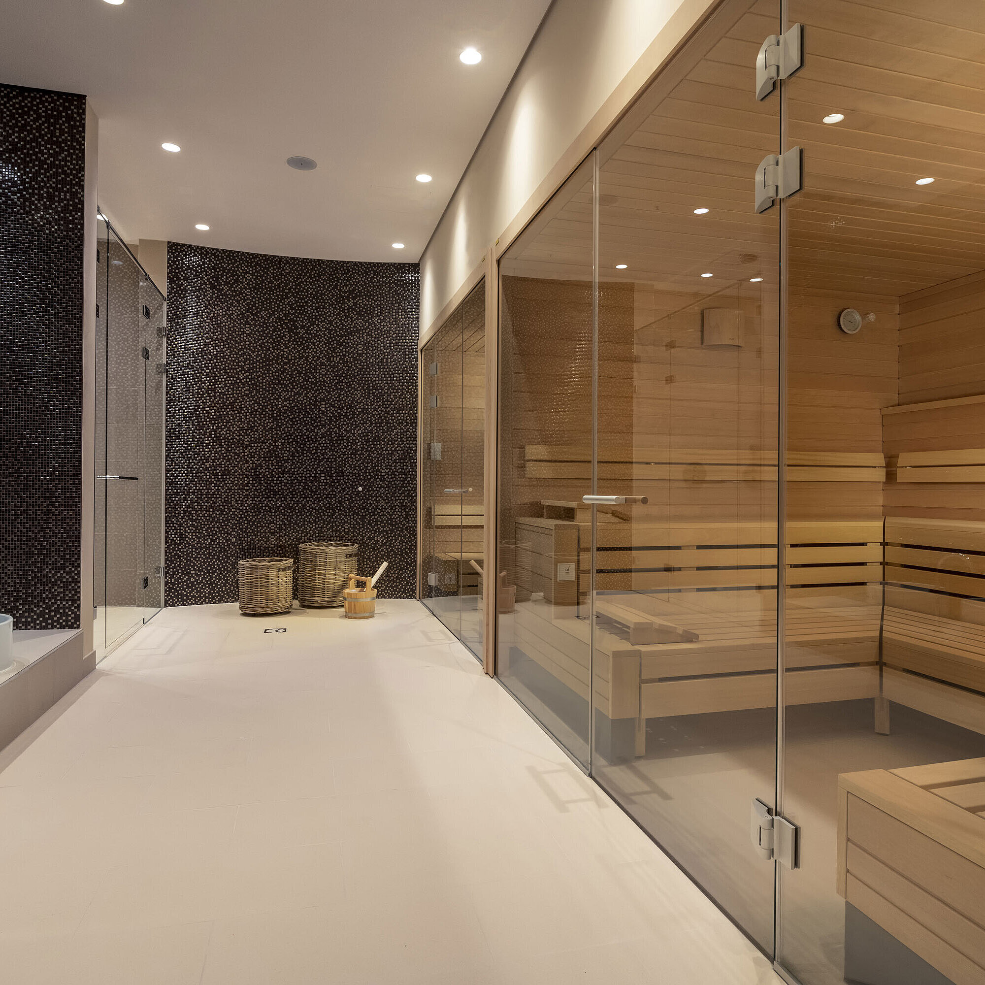 Sauna Modern spa area with glass sauna, cozy seating, and a stylish atmosphere at Maritim Hotel Ingolstadt.