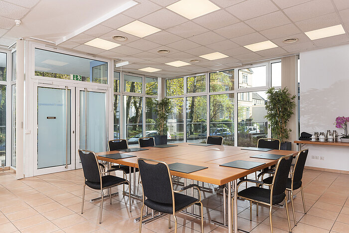 Sala de conferencias con grandes ventanales y acceso directo a la terraza en el Maritim Hotel Königswinter.