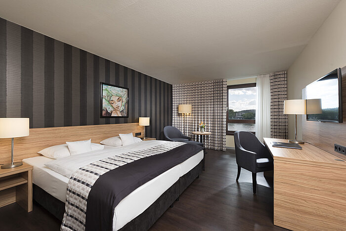 Chambre double élégante de l'hôtel Maritim Königswinter avec vue sur le Rhin et design moderne.