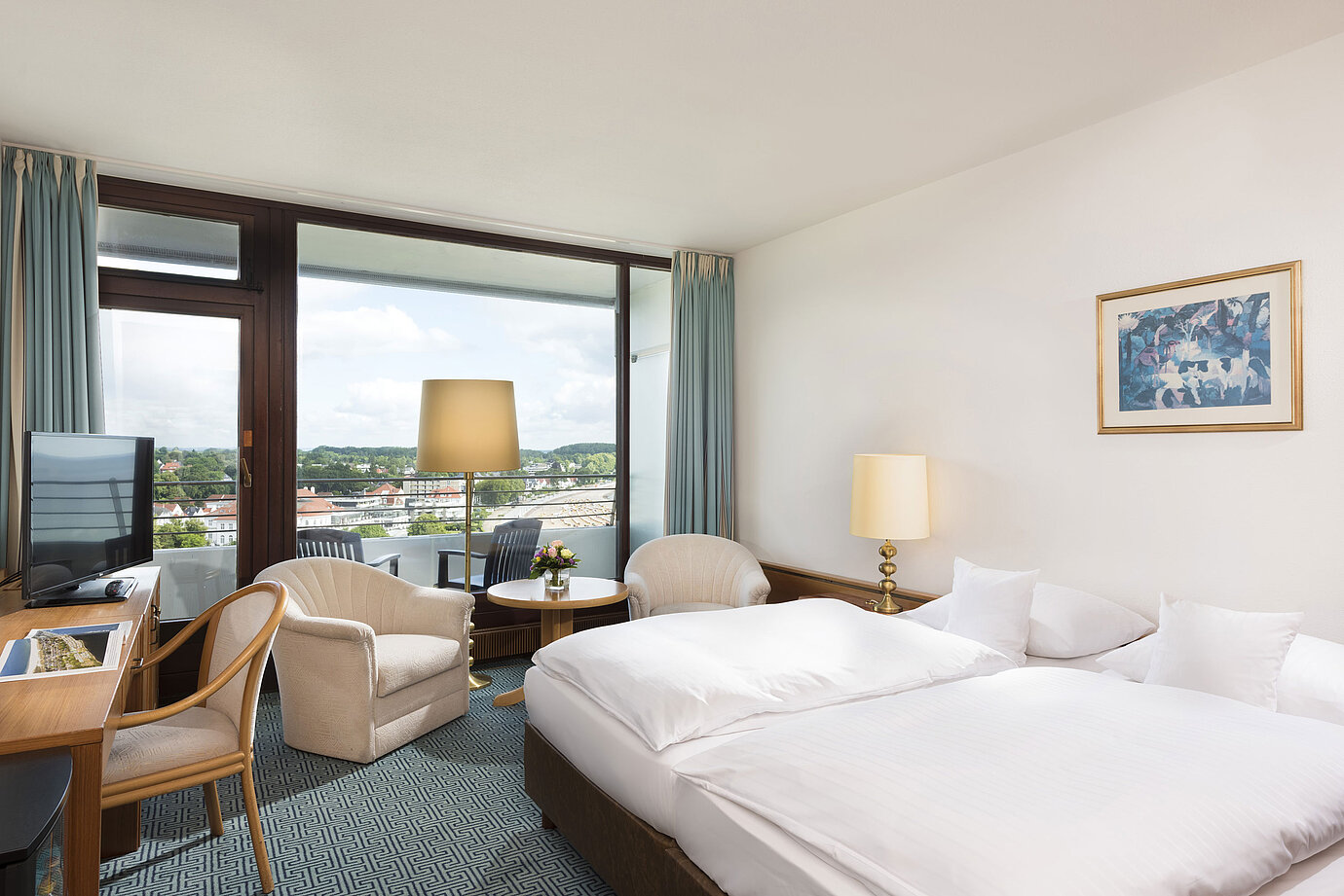 Bright double room at Maritim Hotel Travemünde with balcony and view over rooftops and water
