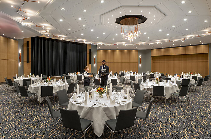 Gran salón de banquetes Barbarossa en el Maritim Hotel Würzburg con mesas redondas y ambiente elegante.
