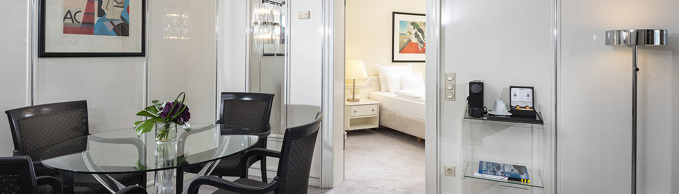 Suite Exécutive lumineuse au Maritim Hotel Frankfurt avec coin repas élégant, table en verre et accès direct à la chambre.