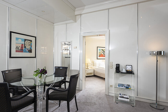 Luminosa Executive Suite al Maritim Frankfurt con zona pranzo elegante,tavolo in vetro e accesso diretto alla camera da letto