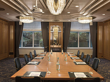 Sala de reuniones con gran mesa, sillas y lámparas en el Maritim Hotel Stuttgart