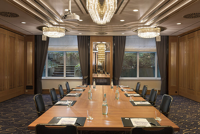 Sala de reuniones con gran mesa, sillas y lámparas en el Maritim Hotel Stuttgart