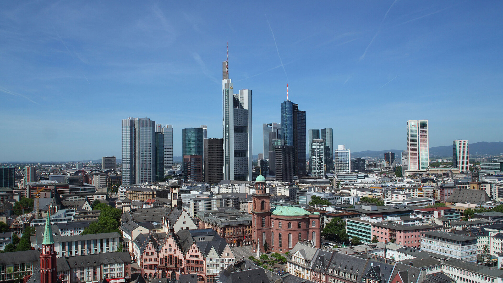 View of Frankfurt's skyline with the Römer and St. Paul's Church in the foreground on a clear day.