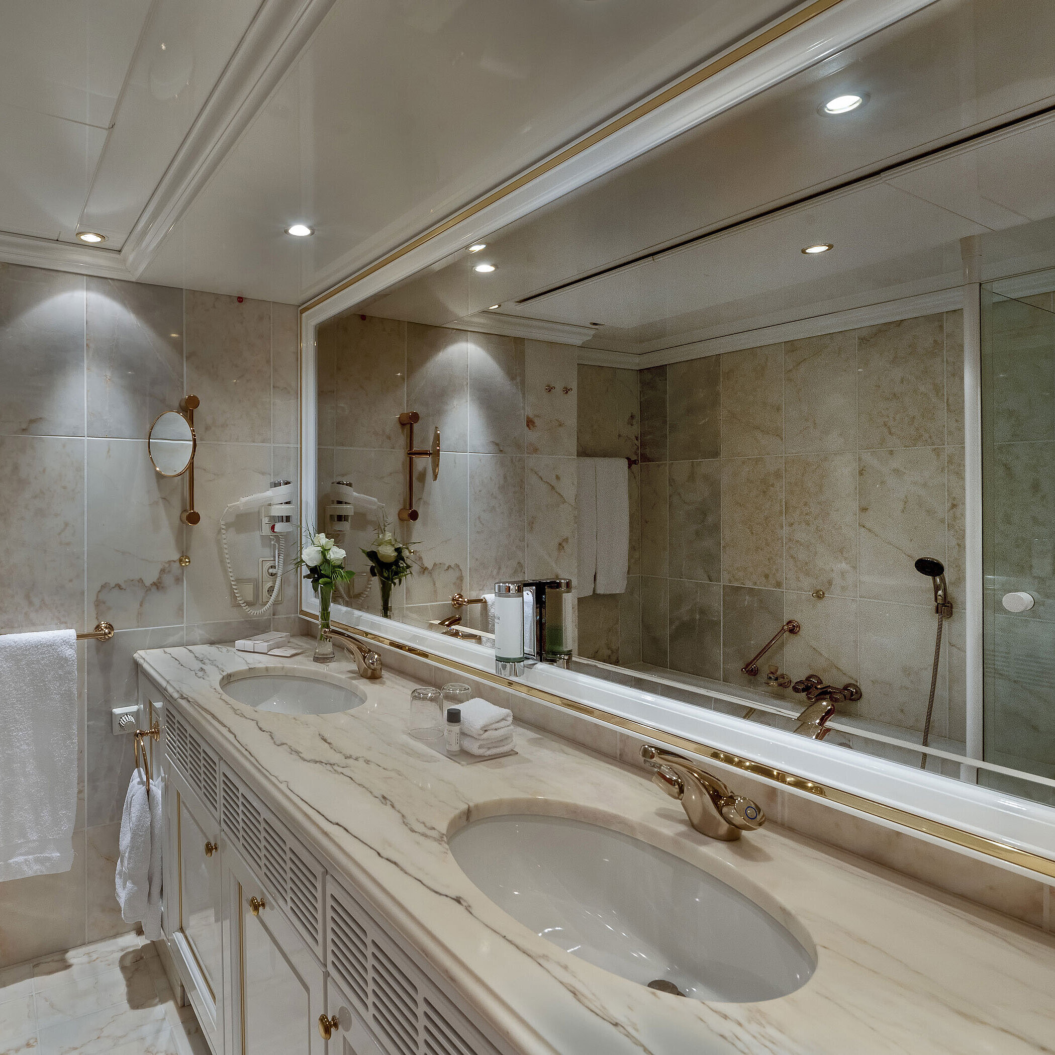 Bath Bagno in marmo nel Maritim Airport Hotel Hannover con doppio lavabo, specchio e vasca da bagno.
