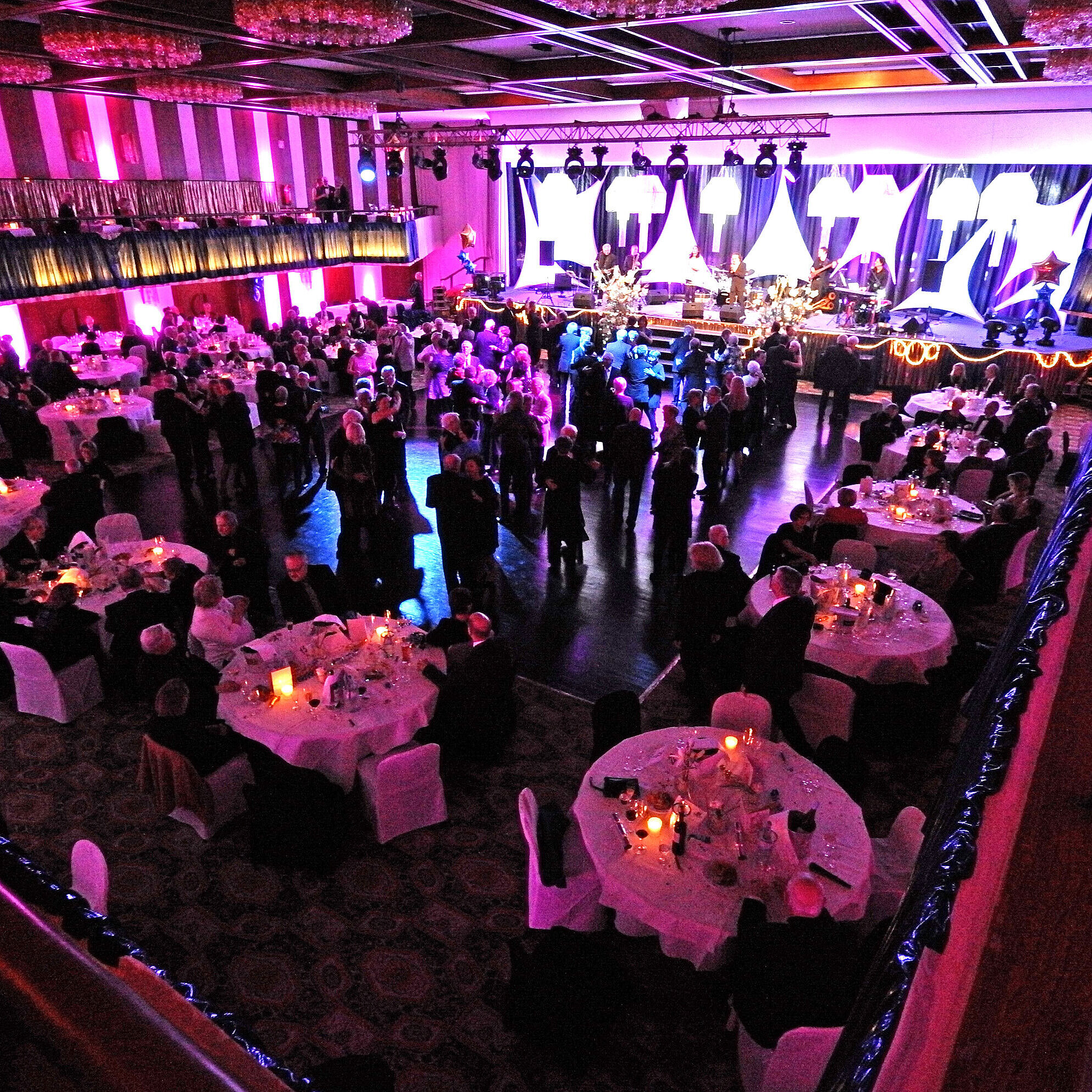 Evening event with stage and banquet seating in festively lit hall of Maritim Hotel Travemünde