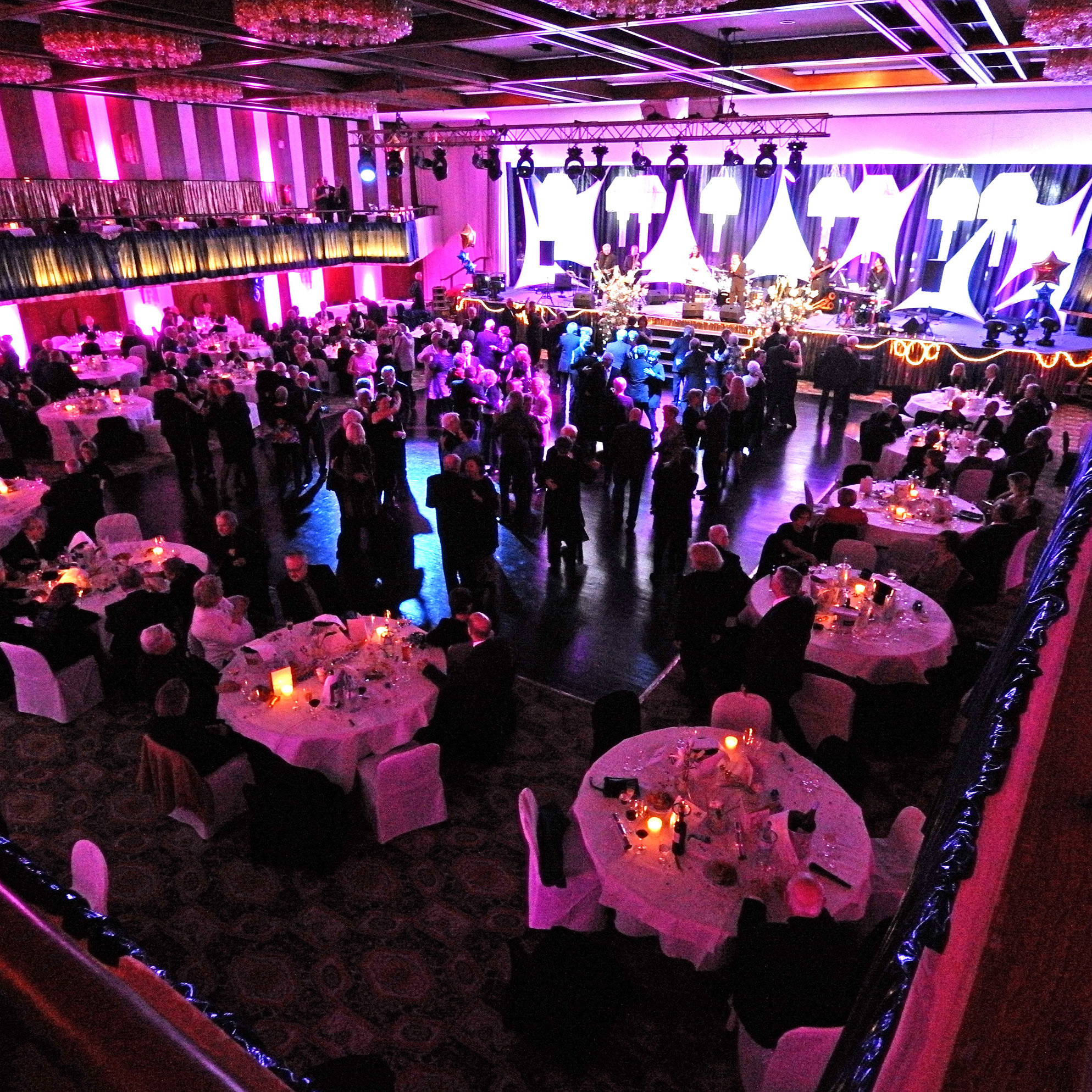 Evening event with stage and banquet seating in festively lit hall of Maritim Hotel Travemünde