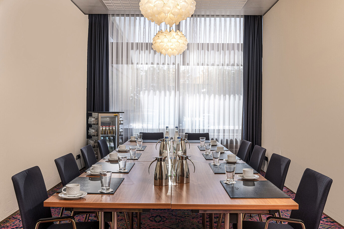 Sala de reuniones pequeña con ventana, luz natural y bebidas en el Maritim Hotel Travemünde