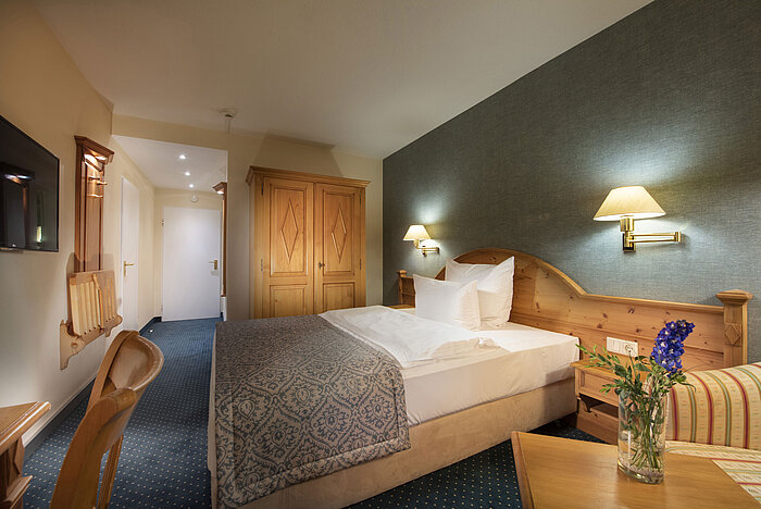Single room at Maritim TitiseeHotel with wooden wardrobe, desk and reading corner