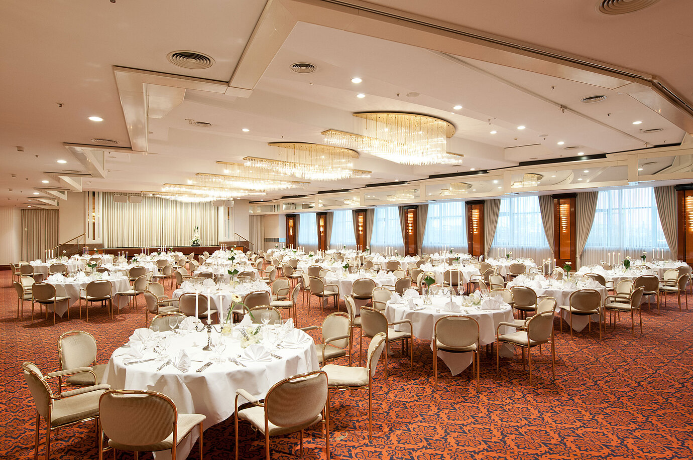 Salón de banquetes elegante con lámparas, mesas decoradas y ambiente sofisticado en el Maritim Hotel Magdeburg.