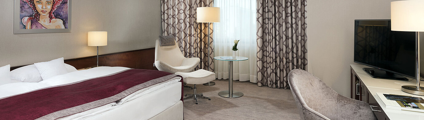 Comfort room  Comfort room at Maritim Hotel Bonn with cozy bed, chairs, desk, and modern curtains.