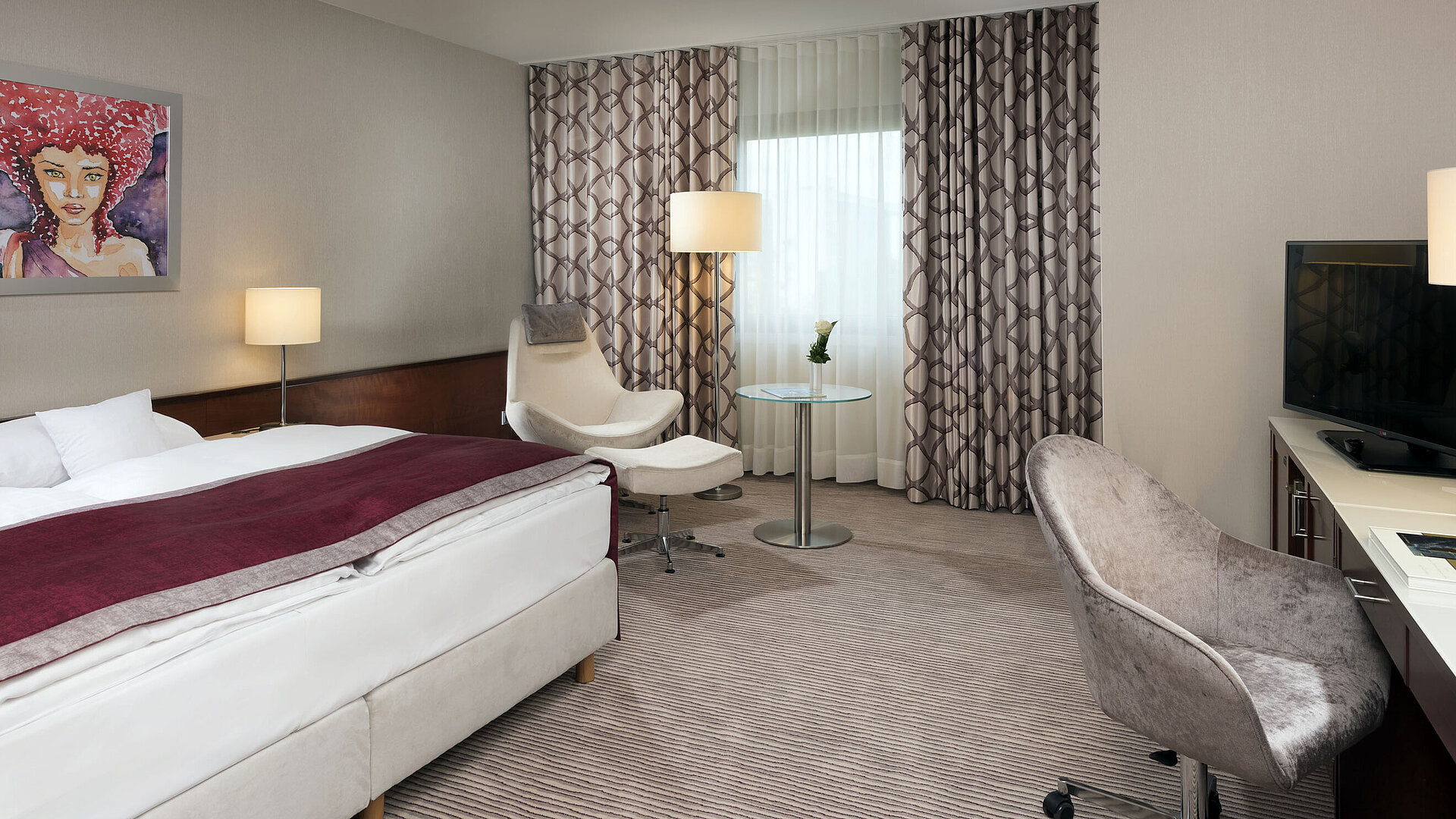 Camera Comfort al Maritim Hotel Bonn con letto accogliente, sedie, scrivania e tende moderne.