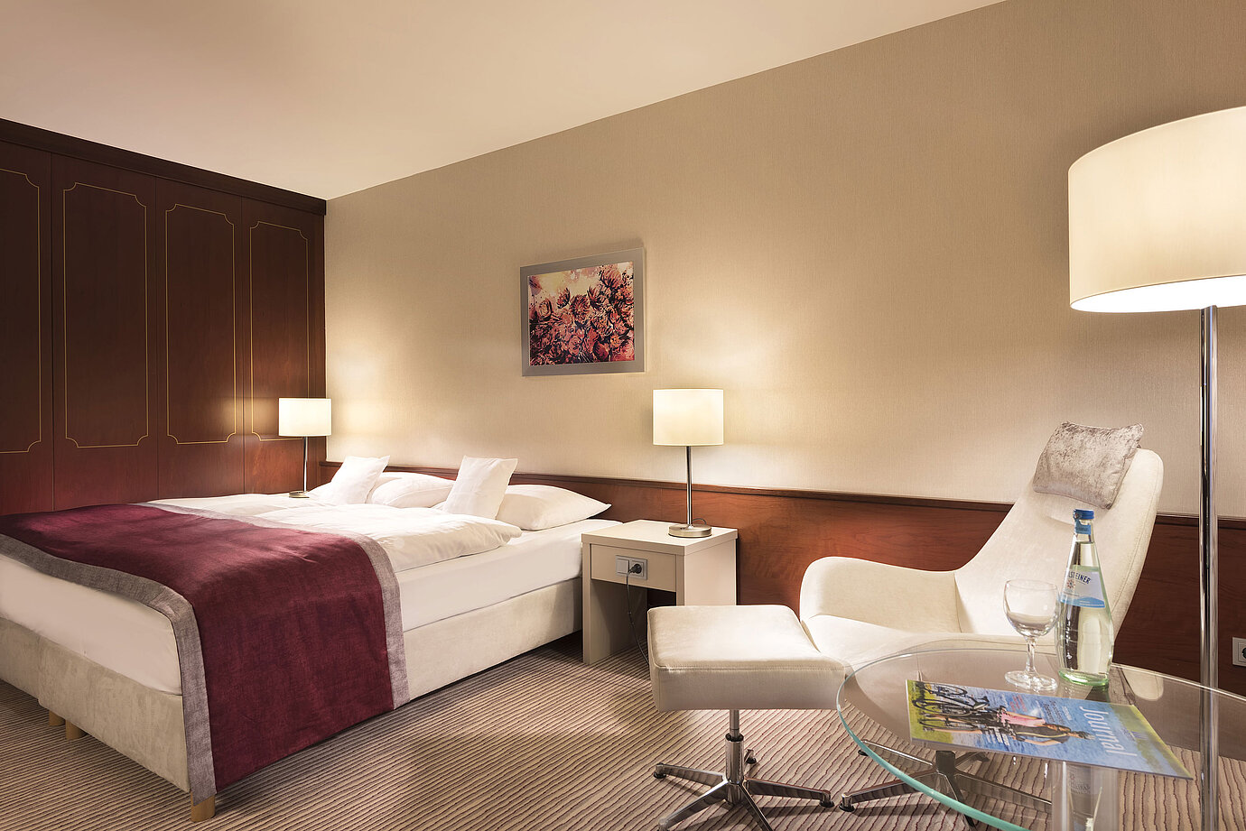 Camera classica al Maritim Hotel Bonn, arredata con letto matrimoniale, poltrona, tavolo e illuminazione moderna.