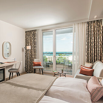 Habitación luminosa del Maritim Hotel Amelia con escritorio, zona de estar y vista al mar desde el balcón