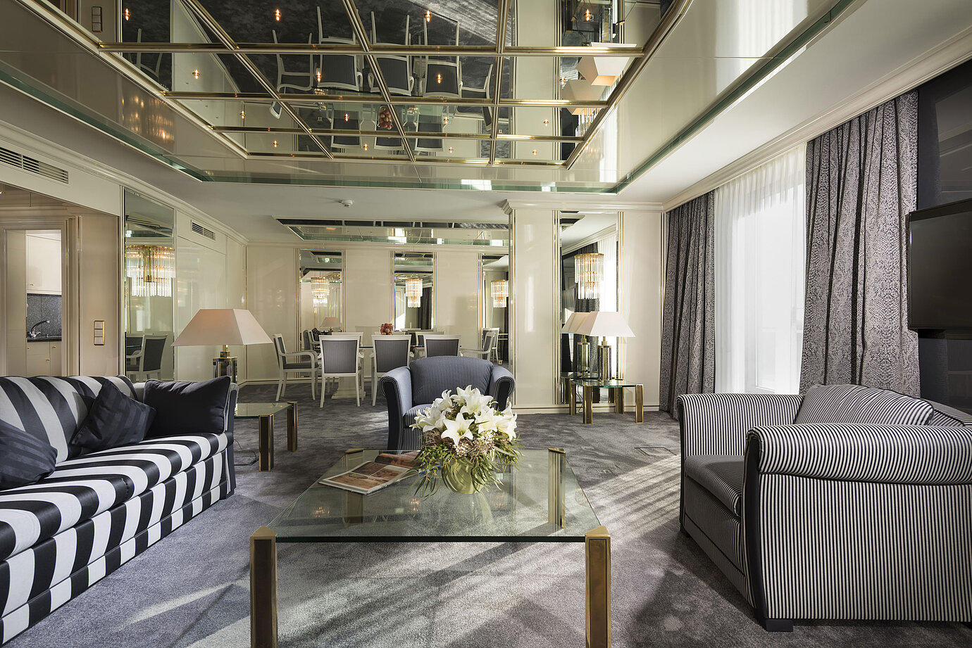 Suite di lusso al Maritim Hotel Ulm con soffitto a specchio, salotto e tavolo da pranzo