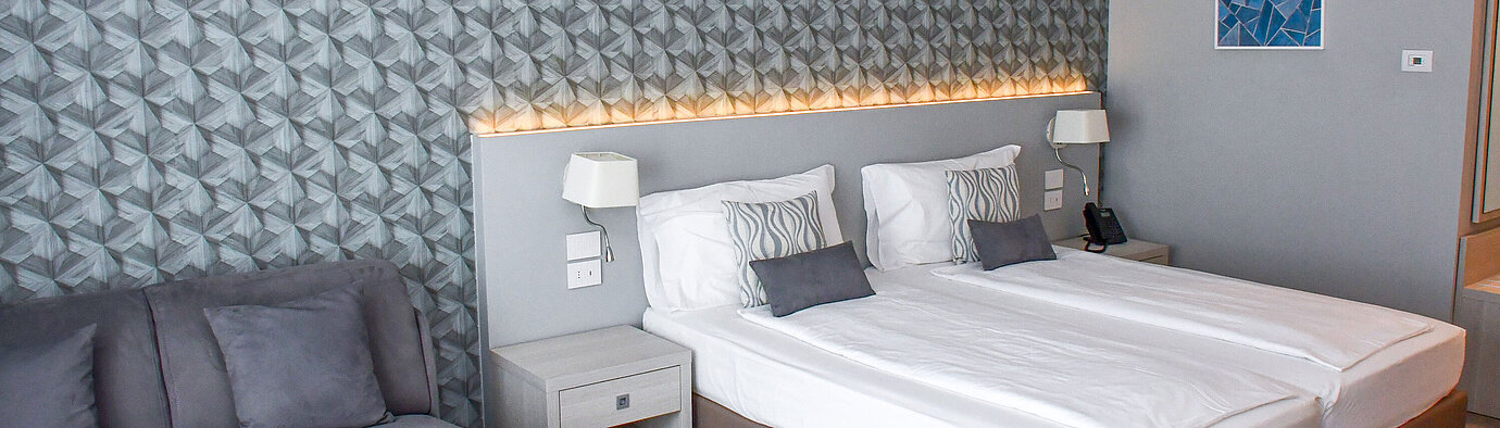 Chambre Superior Grande chambre du Maritim Resort Calabria avec lits jumeaux, canapé et mur design