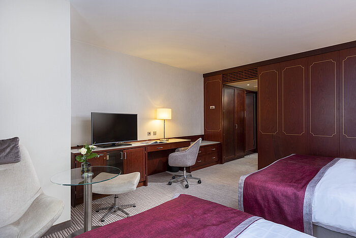Camera familiare al Maritim Hotel Bonn con servizi moderni, letti confortevoli e scrivania pratica.