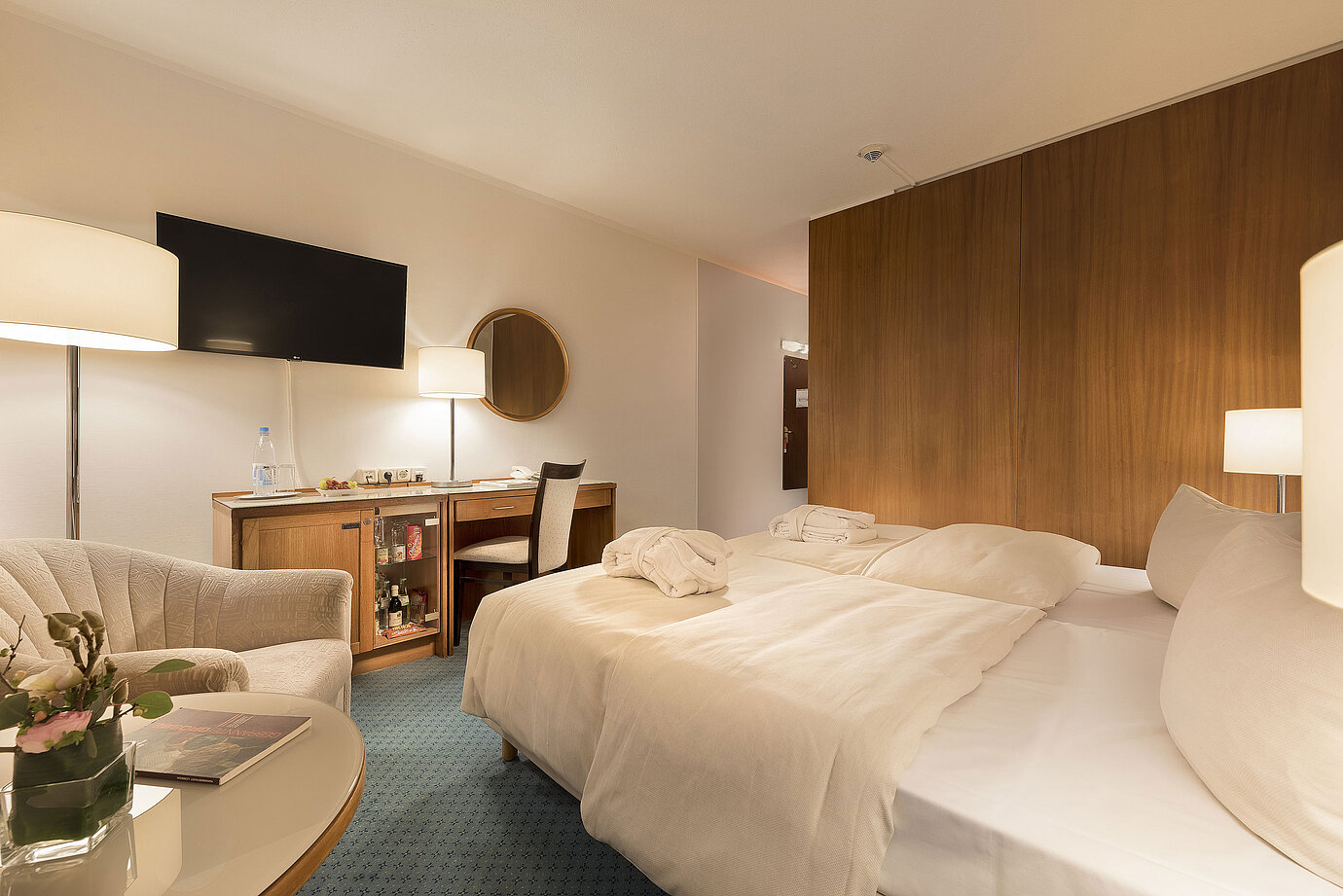 Chambre classique au Maritim Seehotel Timmendorfer Strand avec lits jumeaux, minibar, bureau, TV et coin salon.