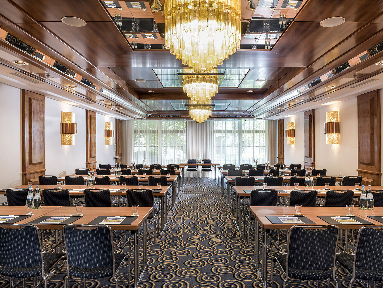 Stylish meeting room with large chandeliers, natural light, and modern seating at Maritim Hotel Königswinter.