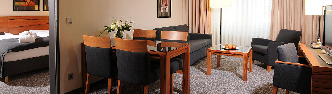 Suite spacieuse avec salon, table à manger et chambre séparée à l’hôtel Maritim Munich