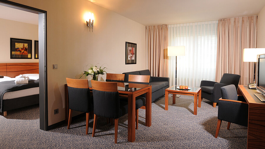 Suite spacieuse avec salon, table à manger et chambre séparée à l’hôtel Maritim Munich